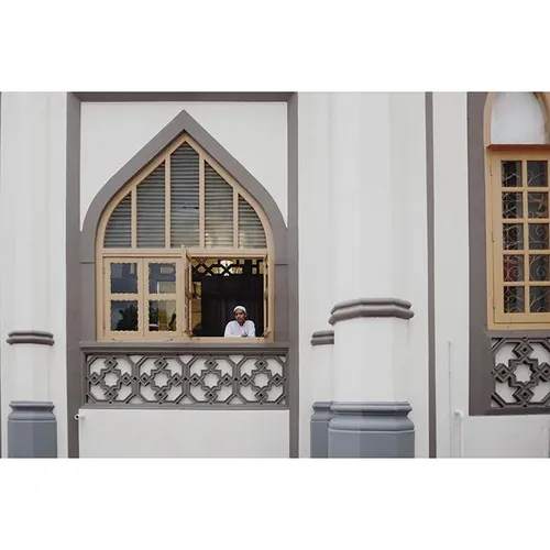 A muslim boy stood by the window at Sultan Mosque also kn
