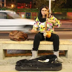 A woman plays the kamancheh, an Iranian bowed string inst