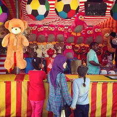 A trio of friends contemplate carnival games at #Dubai Cr