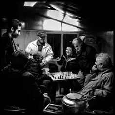 Men spend their leisure time together playing chess. #Teh