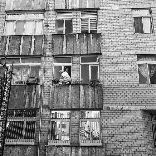 A man is busy cleaning a window. Tehran, Iran. Photo by M