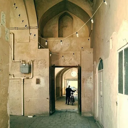 A man walks in a passage to the back of MirEmad Mosque, a