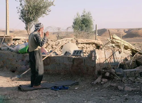 عکس | اقامه نماز پیرمرد زلزله زده در کنار ویرانی ها زلزله