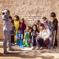 Photographer shows her photos to the children of Afghan r
