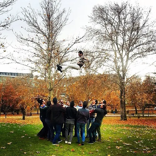 Friends have fun using a trampoline in Mellat Park. Tehra