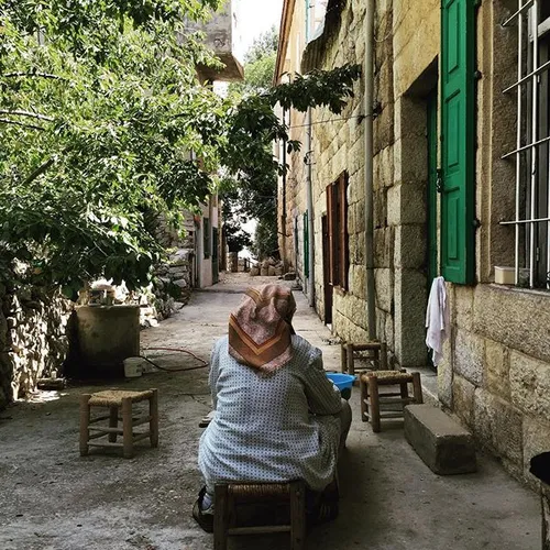 Damia, 82, sits on the stairs next to her house in Ehden 