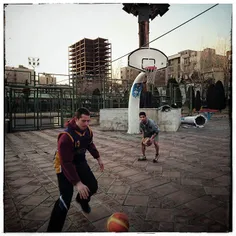 Young boys playing basketball in a park in centelre of Te