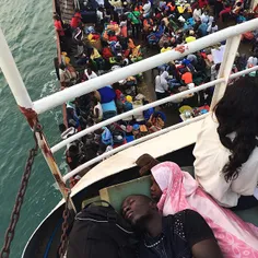 Two young men sleep on a ferry traveling to Bissau from B
