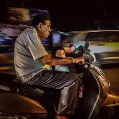 A man rides a bike with his child in Gujarat, India. Phot