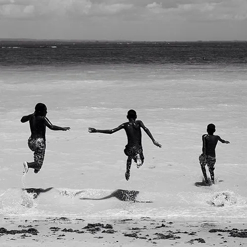 Kids run into the ocean in Gamboa, Bahia, Brazil. Picture