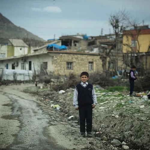 A Kurdish boy stands at the entrance of Koçtepe village i