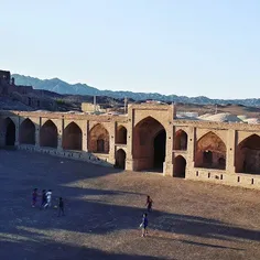 Kids play football at the courtyard of an old inn dated b