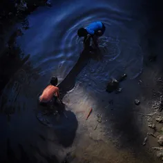 Nepalese boys try to find fish in the Bagmati river in Ka