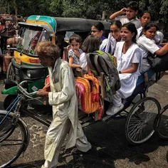 An elderly Indian cycle-rickshaw driver pulls his ricksha