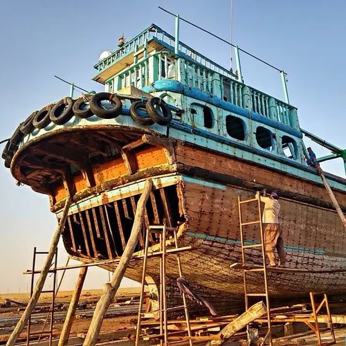 A man repairing a Lanj boat by the coast of PersianGulf, 