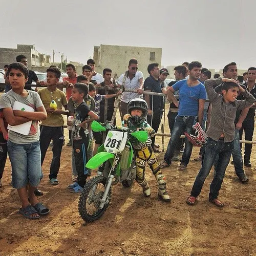 People watch motorcyclists competing in the National Moto