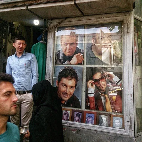 People walking by a photography shop. Tehran, Iran. Photo