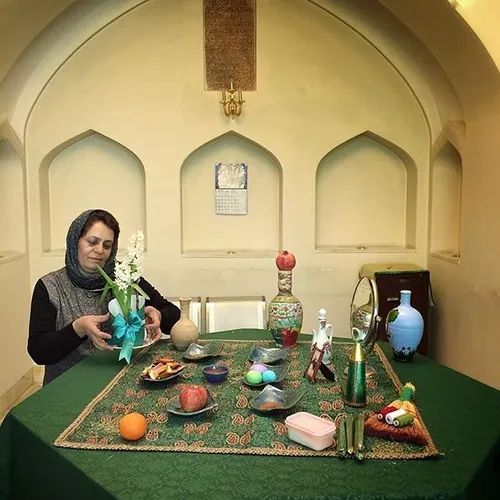 A woman making Sofreye Haft-Sin (Haft-Sin table) ready be