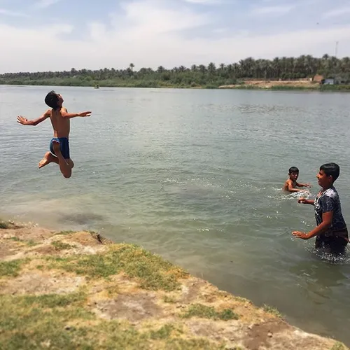 Kids swim in the Euphrates river at Saddat al Hindiyah in