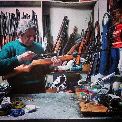 A man repairing a hunting weapon at his gun shop in Tehra