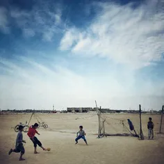 Boys playing football on a sandy ground in Shif Island, #