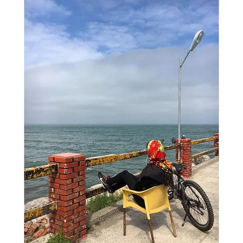 A girl has parked her bike and is enjoying the view of th