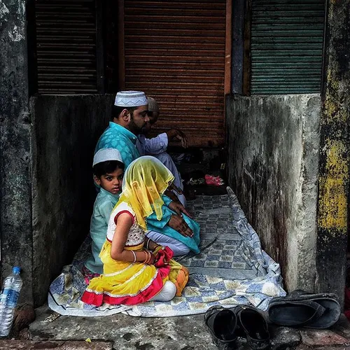 An Indian Muslim girl offers prayers with her family duri