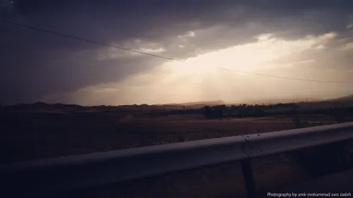 خورشید پشت ابر در کنار جاده