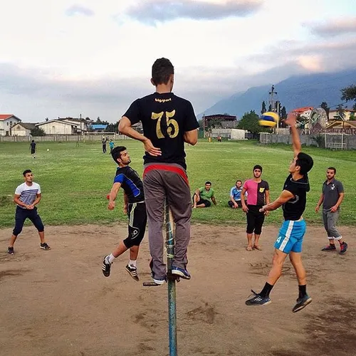 Men play volleyball at a sports field in Chalk Village, M