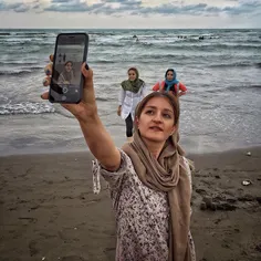 An Iranian girl makes #selfie on the beach of Caspian sea