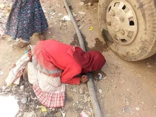 دختر خردسال یمنی که از فرط تشنگی سعی دارد از نشتی لوله در