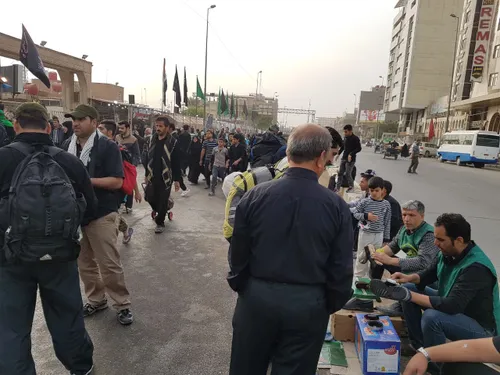 تصاویر واکس زدن کفش های زائرین اربعین حسینی توسط خادمین م