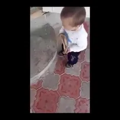 خفه کردن یک مار توسط کودک با تشویق پدر