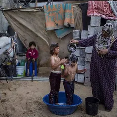 Palestinian mother Rana Soboh, 32, washes her daughters A