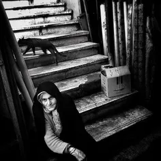 An old woman resting on some stairs in the bazaar of #Ras