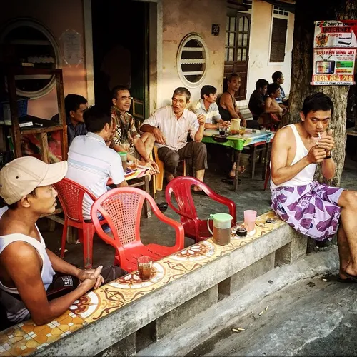 Men chit chat and get relax together at a street coffee s