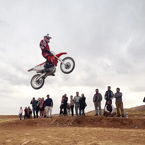 People watch a motocross rider performing at Tellow, Lava