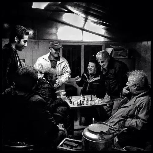 Men spend their leisure time together playing chess. Tehr