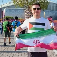 این فرد آمریکایی با پرچم فلسطین در لباسش و پرچم ایران در 
