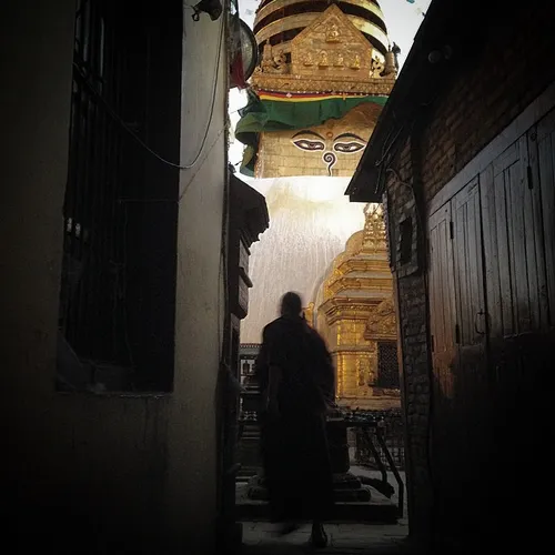 A Buddhist monk walks infront of Swayambhunath Stupa in K