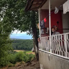 A man sitting at his terrace,with a view of rice fields a