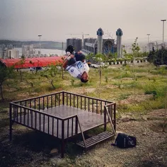 A traceur practicing parkour on an open field near to Chi