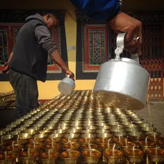 Nepalese men make butter lamp in a monastery near Boudhan