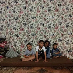 Syrian refugee children watch TV inside an apartment at a