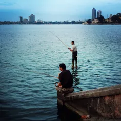 Men are fishing on West lake at dusk, Hanoi, Vietnam (Apr