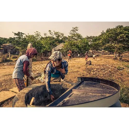 A young woman gathers water from a well in Dala, a rural 