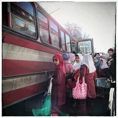 Elementary school girls waiting to get on tye school bus 