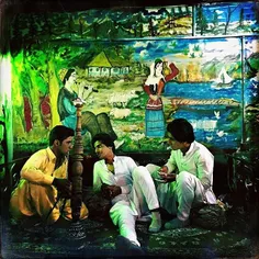 Baluchi men smoke ghalyn (hookah) in a traditional cafe. 