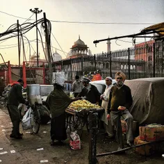 A roadside fruit vendor is surrounded by the customers in