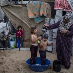 #Palestinian mother Rana Soboh, 32, washes her daughters 